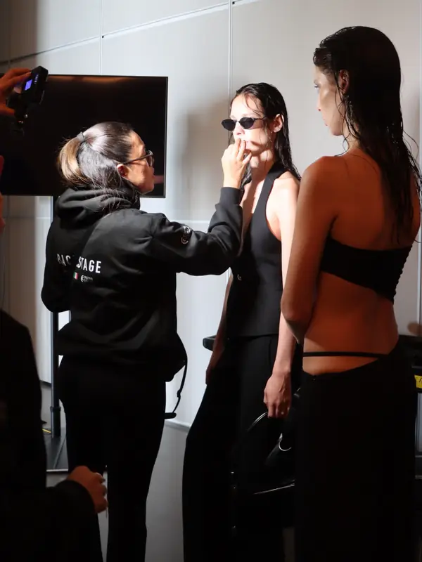 Maquilladora del equipo de Cristina Cuéllar retocando a una modelo en backstage