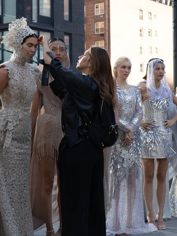 Equipo de maquillaje dando retoques a modelos antes de un desfile